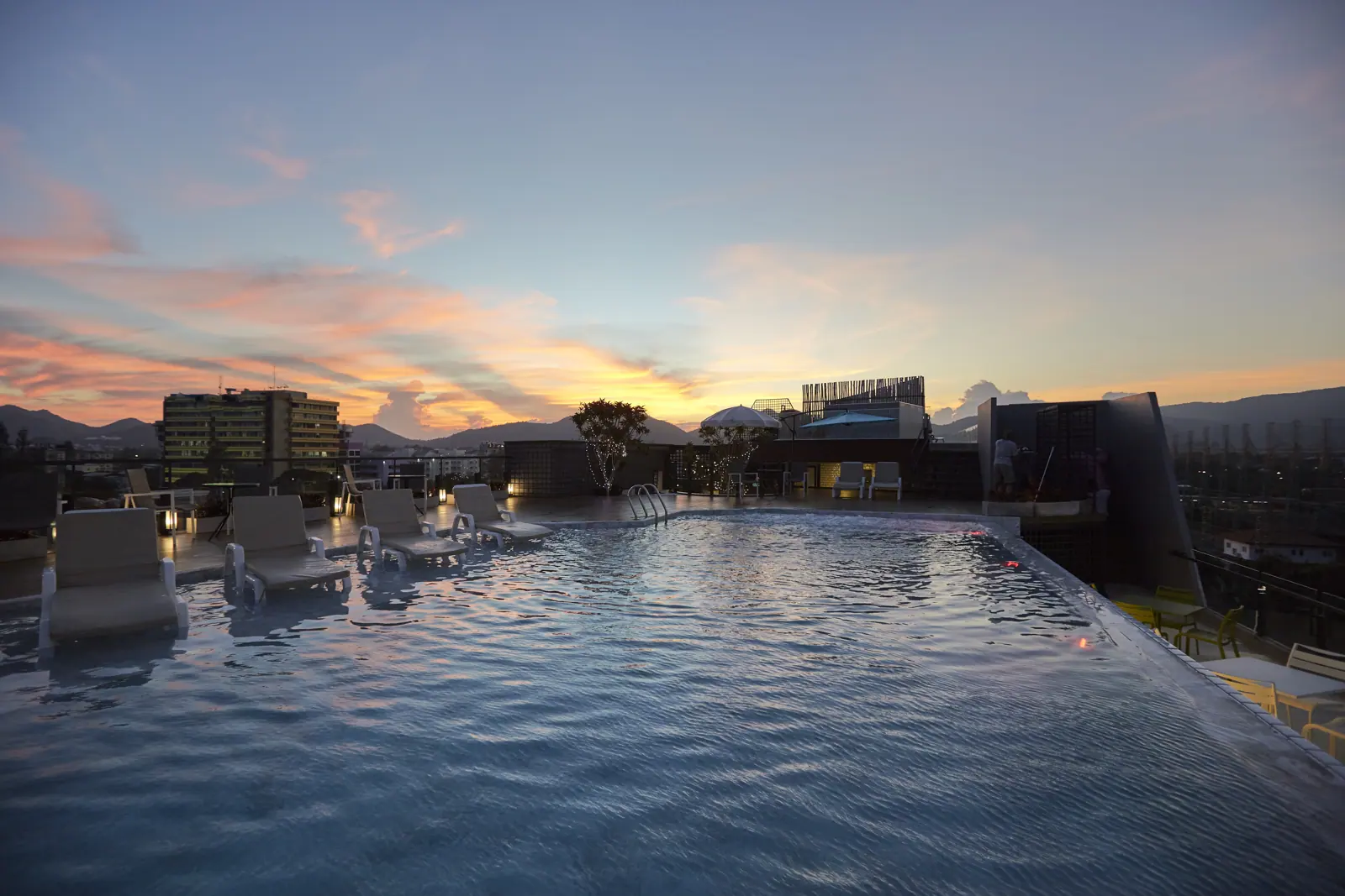 Rooftop pool at sunset and night